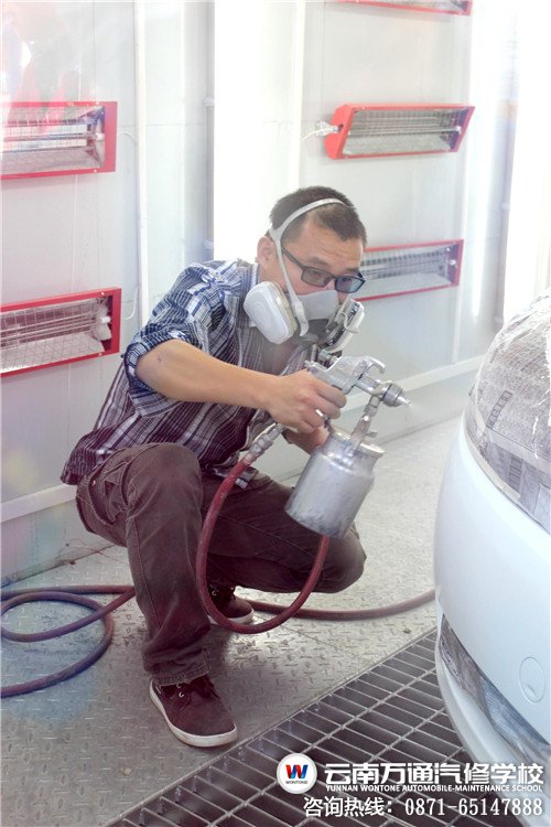 在噴烤漆房內教授噴漆知識的羅老師