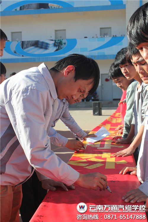 正在宣傳橫幅上簽字的萬通班主任老師.jpg